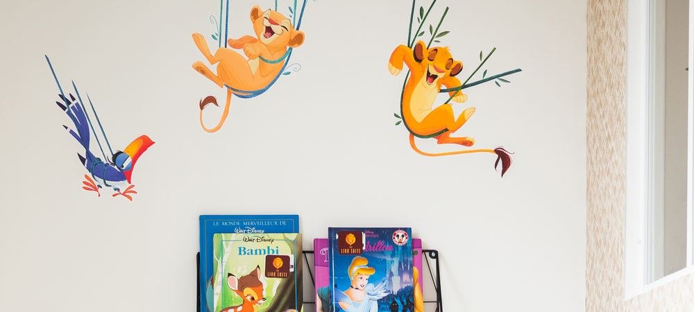 Lion King wall decals and Disney books in bedroom 2 of The Lion Suite