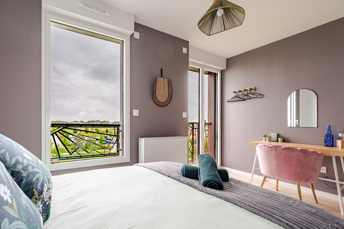 Main bedroom with balcony and a desk corner